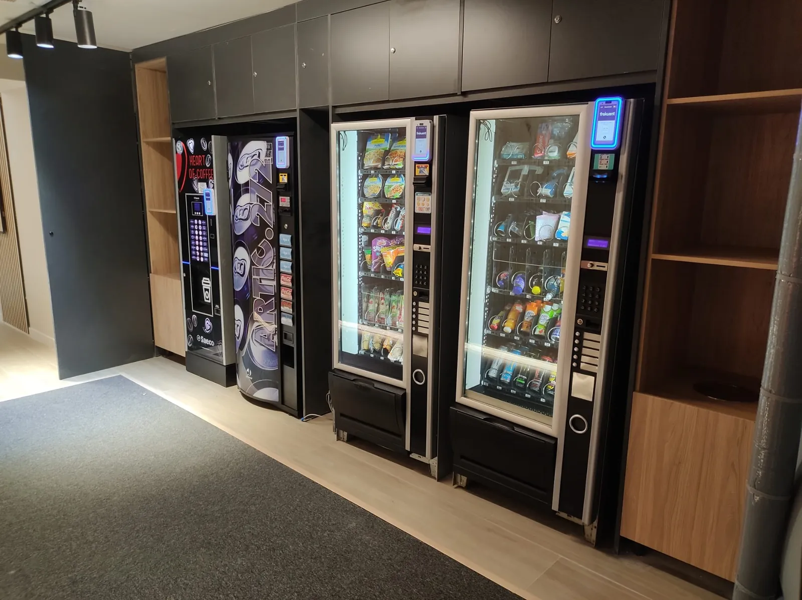 Cuatro máquinas vending de café, bebidas y snacks integradas en un mueble de madera en el hotel Futurotel, en Madrid